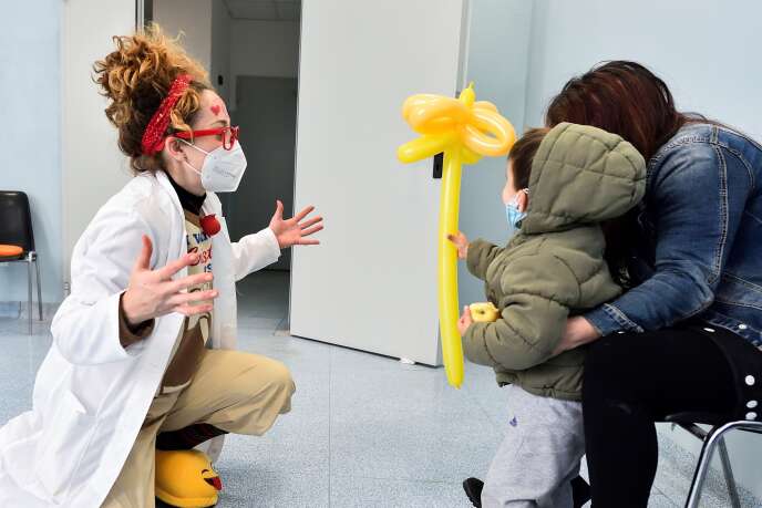 Un clown distrait un enfant qui a reçu un vaccin contre la grippe à Milan le 20 novembre 2020.