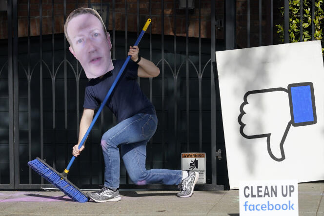 Un homme, balai en main et masque de Mark Zuckerberg sur le visage, manifeste le 21 novembre à proximité de la maison du patron de Facebook pour l’inviter à « nettoyer Facebook ».