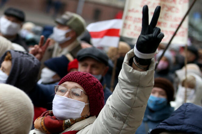 Une femme brandit le signe V, alors que des retraités biélorusses défilent dans les rues lors d’un rassemblement de protestation contre les violences policières à Minsk, le 23 novembre 2020.