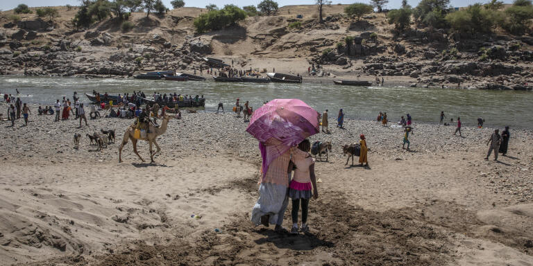Tigray refugees who fled the conflict in the Ethiopia's Tigray arrive on the banks of the Tekeze River on the Sudan-Ethiopia border, in Hamdayet, eastern Sudan, Saturday, Nov. 21, 2020. The U.N. refugee agency says Ethiopia's growing conflict has resulted in thousands fleeing from the Tigray region into Sudan as fighting spilled beyond Ethiopia's borders and threatened to inflame the Horn of Africa region. (AP Photo/Nariman El-Mofty)