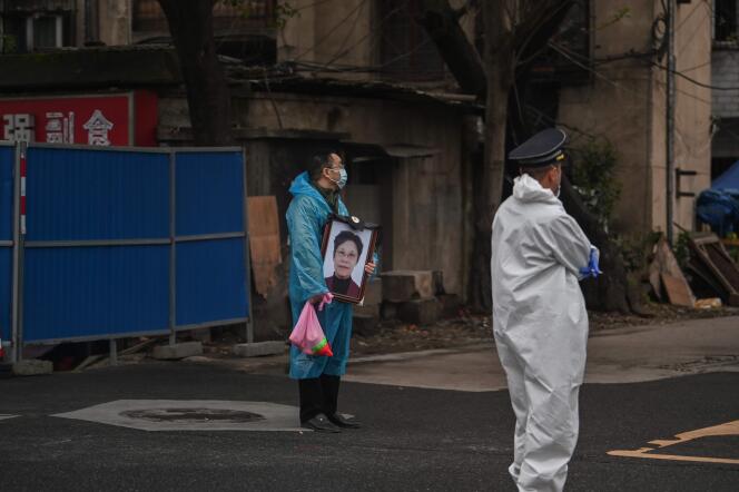 Un proche tient le portrait d’une victime du Covid-19 près du cimetière Biandanshan à Wuhan dans la province du Hubei en Chine, le 31 mars.