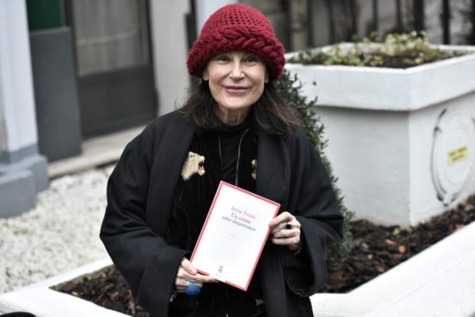 L’autrice française Irène Frain pose avec son livre « Un crime sans importance », après avoir remporté le prix Interallié, devant le restaurant (fermé) Lasserre, à Paris, le 3 décembre 2020.
