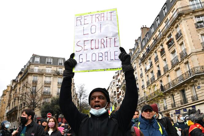 Un manifestant brandit une pancarte appelant au retrait de la loi « sécurité globale » à Paris, le 5 décembre 2020.