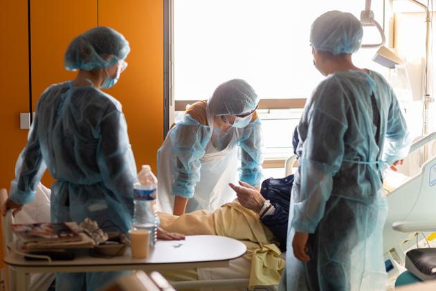 Une médecin gériatre ausculte un patient atteint du Covid-19 au service de gériatrie de l’hôpital Bichat à Paris, le 8 décembre.