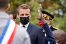 French President Emmanuel Macron wearing a protective face mask speaks watches a child as he arrives at 'la Maison des habitants' (MDH) to meet and have lunch with young representatives of the MDH in Les Mureaux, northwest of Paris on October 2, 2020. (Photo by Ludovic MARIN / POOL / AFP)