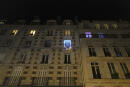 French tenor singer Stephane Senechal sings Christmas songs, at dusk, from his apartment window decorated with balloons during the partial lockdown, in Paris, Tuesday, Dec. 15, 2020. France on Tuesday is lifting a lockdown imposed on Oct. 30, but starts a new curfew at 20h00, local time, as infections are still high. (AP Photo/Francois Mori)