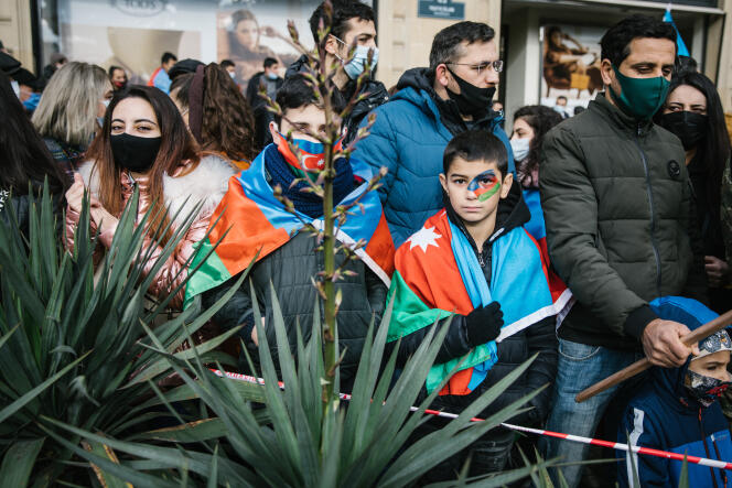 A Bakou, le 10 décembre 2020, des manifestants grimés aux couleurs du drapeau national, assistent à la parade militaire après la reprise des territoires arméniens du Haut-Karabakh par les troupes azerbaïdjanaises.