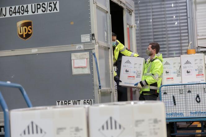 Des employés d’UPS portent des cartons de vaccins Pfizer contre le Covid-19 pour les envoyer au Canada, à Cologne (Allemagne), le 11 décembre.