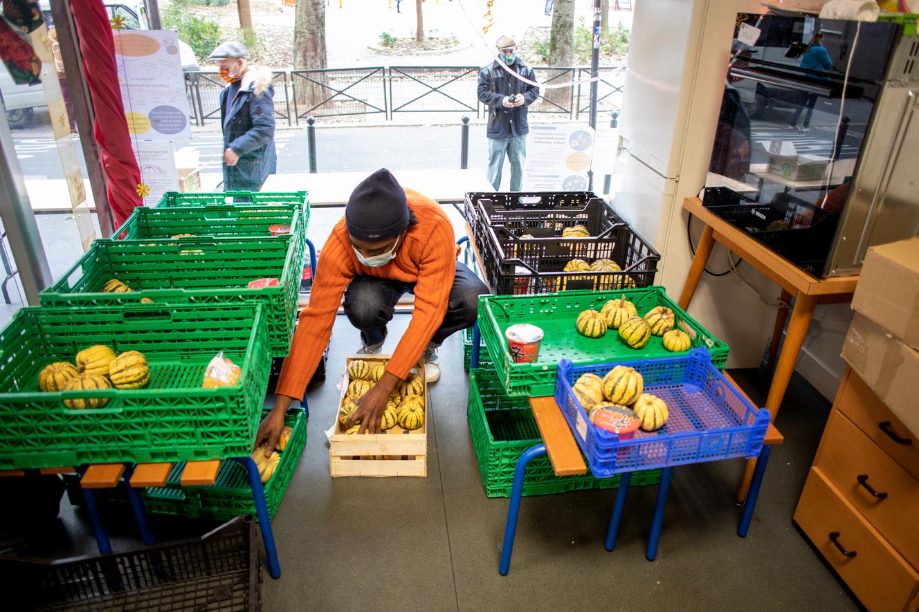 Distribution alimentaire par des bénévoles de l’association Les Marmoulins de Ménil’, à La Maison du bas Belleville, à Paris, le 2 décembre.