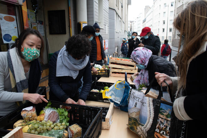 Distribution alimentaire par des bénévoles de l’association Les Marmoulins de Ménil’, à La Maison du bas Belleville, à Paris, le 2 décembre.