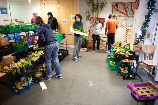 Distribution alimentaire par des bénévoles de l’association Les Marmoulins de Ménil’, à La Maison du bas Belleville, à Paris, le 2 décembre.