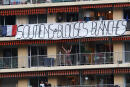 People display on a balcony a banner reading "Support to white Coats (Healthcare workers)" as they applaud every evening at 20:00 along with others across the French nation, to show their support to healthcare employees, in the French Riviera city of Nice, southern France on April 24, 2020, on the 39th day of a strict lockdown aimed at curbing the spread of the COVID-19 pandemic, caused by the novel coronavirus. (Photo by VALERY HACHE / AFP)