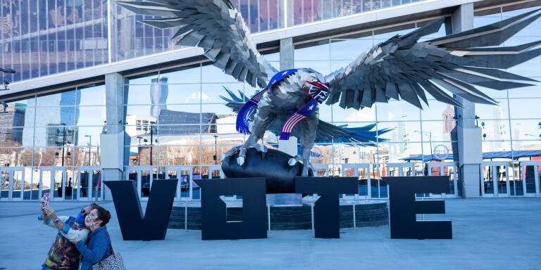 People take a selie in front of a statue of a Falcon at the Mercedes-Benz Stadium, home of the Atlanta Falcons, being used as an early voting location in Downtown Atlanta, Georgia.22/12/2020
Crédit: Dustin Chambers pour Le Monde