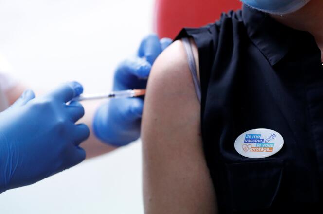 Une patiente se fait vacciner et arbore un badge « Je me vaccine, je vous protège », le 7 janvier, à l’hôpital de Vannes.