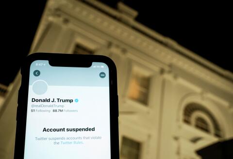 A photo illustration shows the suspended Twitter account of U.S. President Donald Trump on a smartphone and a lit window in the White House residence in Washington, U.S., January 8, 2021. REUTERS/Joshua Roberts/Illustration