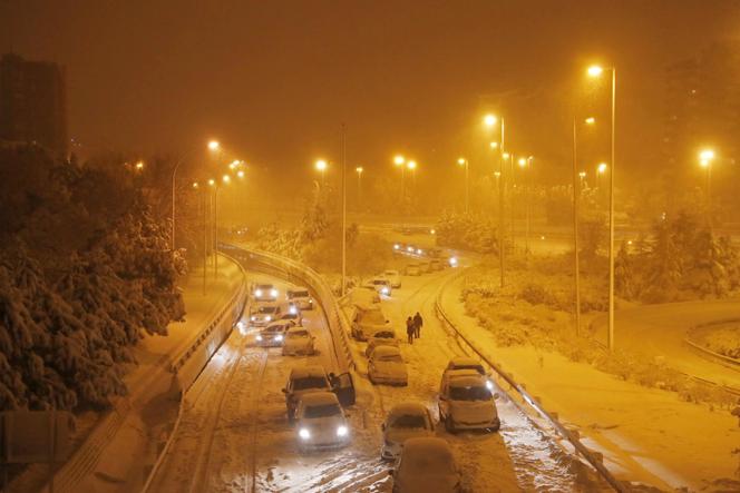 Les automobilistes abandonnent leurs voitures au ralenti sur une rampe d'accès à l'autoroute M-30, près de Madrid, dans la nuit du 8 au 9 janvier 2021.