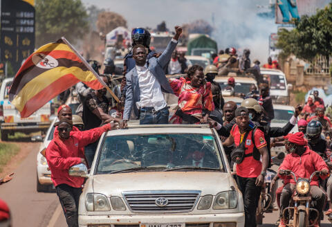 Ugandan musician-turned-politician Robert Kyagulanyi, also known as Bobi Wine (C), greets supporters as he sets off on his campaign trail towards eastern Uganda, near Kayunga, on December 1, 2020. - Bobi Wine is concluding his campaign rallies all over the country in preparation for the upcoming 2021 elections, where he will be challenging Ugandan President Yoweri Museveni, who has been in power for 35 years. (Photo by Sumy Sadurni / AFP)