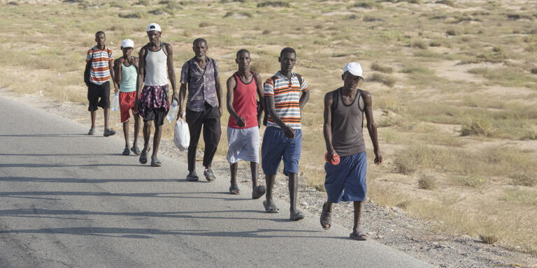 African migrants who arrived in Yemen by boat walk toward Saudi Arabia on the road between Ataq and the coast, in Shabwa province, Yemen, on November 13, 2020. [Sam Tarling / Sana’a Center / ]