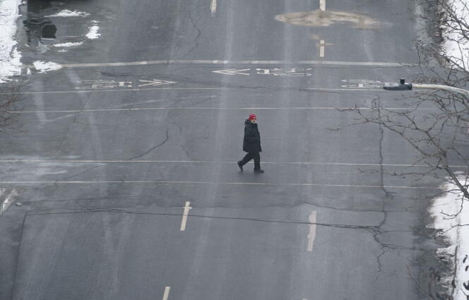 Un piéton traverse une rue déserte de Montréal, le 13 janvier.