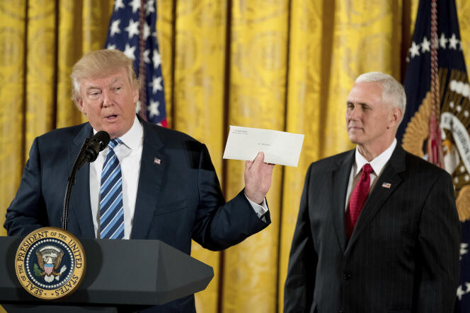 Accompagné du vice-président Mike Pence (à droite), Donald Trump tient la lettre que lui a laissé son prédécesseur Barack Obama, à Washngton, le 22 janvier 2017.