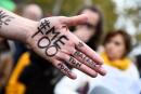 A picture shows the messages "#Me too" and #Balancetonporc ("expose your pig") on the hand of a protester during a gathering against gender-based and sexual violence called by the Effronte-e-s Collective, on the Place de la Republique square in Paris on October 29, 2017. - #MeToo hashtag, is the campaign encouraging women to denounce experiences of sexual abuse that has swept across social media in the wake of the wave of allegations targeting Hollywood producer Harvey Weinstein. (Photo by Bertrand GUAY / AFP)