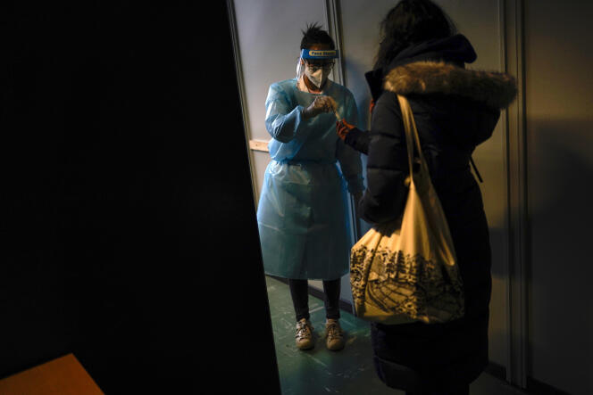 Un travailleur médical accueille une personne arrivant du Royaume-Uni pour un test Covid-19, dans un centre de la Croix-Rouge à la gare internationale de Bruxelles-Midi, le 19 janvier.
