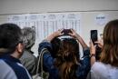 Parents take photos of the results of the baccalaureat exam (high school graduation exam) at the Fresnel high school in Paris, on July 5, 2019. - French high school students face an anxious wait for exam results this week amid protests by teachers who are threatening not to hand over results. (Photo by STEPHANE DE SAKUTIN / AFP)