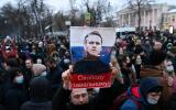 TOPSHOT - Protesters march in support of jailed opposition leader Alexei Navalny in downtown Moscow on January 23, 2021. The placard with an image of the Kremlin critic reads "Freedom to Navalny!". Navalny, 44, was detained last Sunday upon returning to Moscow after five months in Germany recovering from a near-fatal poisoning with a nerve agent and later jailed for 30 days while awaiting trial for violating a suspended sentence he was handed in 2014. / AFP / Kirill KUDRYAVTSEV
