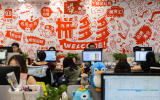 Workers sit on duty at the headquarters of Pinduoduo, an e-commerce platform, in Shanghai Wednesday, July 25, 2018. China's official Xinhua News Agency is calling for shorter work hours in the country's tech sector following the sudden death of a young employee at the leading e-commerce platform. (Chinatopix via AP)