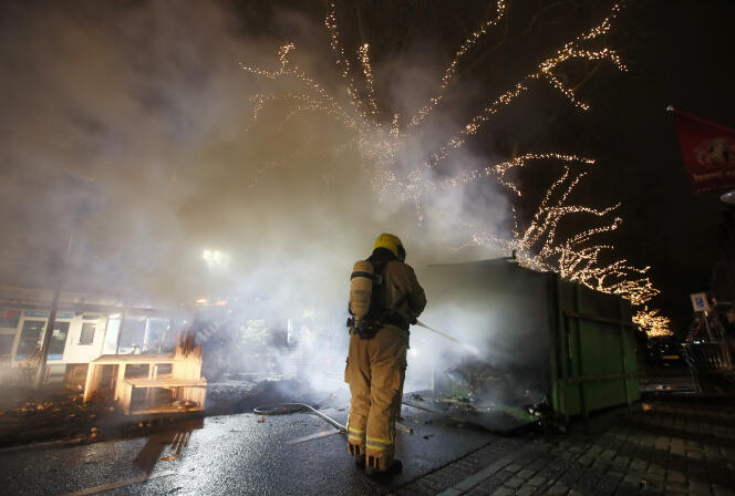 Un pompier éteint un conteneur incendié à Rotterdam, lundi 25 janvier.