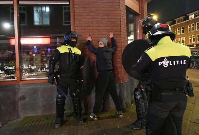 Des policiers néerlandais arrêtent un homme lors d’une patrouille dans les rues de Rotterdam, le 26 janvier 2021, suite aux manifestations après l’adoption de nouvelles règles pour lutter contre la propagation du Covid-19.