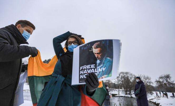 A protester holding the Lithuanian national flag and the portrait of Alexei Navalny during a demonstration in support of the Russian opponent outside the Russian embassy in Vilnius, January 23, 2021.