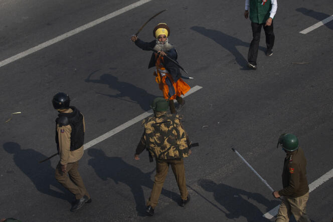 Un Nihang, ou guerrier Sikh, brandit une épée devant un policier pendant les manifestations des agriculteurs à New Delhi, en Inde, le 26 janvier 2021.