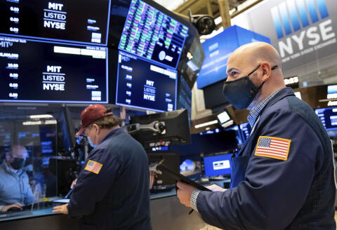 In this photo provided by the New York Stock Exchange, trader Fred Demarco, right, works on the floor, Friday, Jan. 29, 2021. GameStop's stock is back to the races Friday, and the overall U.S. market is down again, as the saga that's captivated and confused Wall Street ramps up the drama. (Nicole Pereira/New York Stock Exchange via AP)