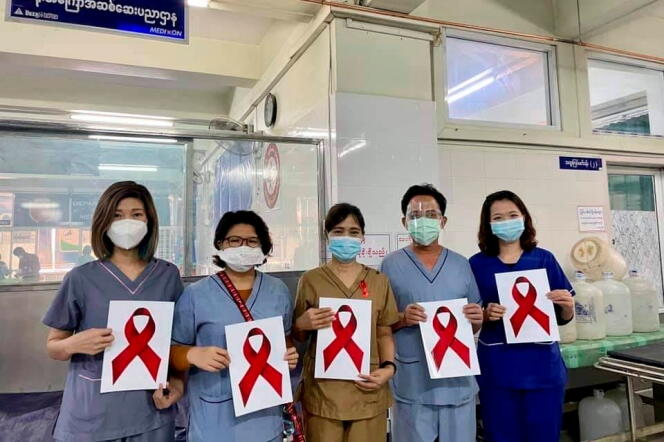 Des travailleurs de la santé tiennent des pancartes représentant un ruban rouge, à l’hôpital général de Mandalay, en Birmanie, le 3 février 2021.