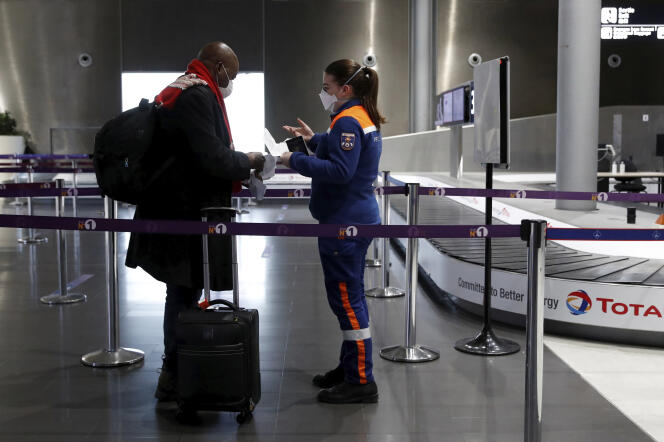 Une membre de la protection civile vérifie les papiers d’un passager à l’aéroport de Roissy-Charles-de-Gaulle, le 5 février.