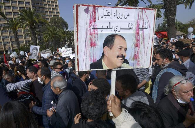 Un manifestant brandit une pancarte demandant qui a assassiné le chef de file de l’opposition de gauche, Chokri Belaïd, lors d’un rassemblement à Tunis contre la répression policière, le 6 février. L’avocat avait été tué le 6 février 2013.