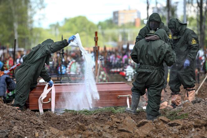 Des employés d’un cimetière de Butovskoye, près de Moscou, désinfectent le cercueil d’une victime du Covid-19 le 15 mai 2020.