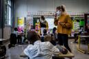 A teacher wearing a mask is at work in a classroom of a school on May 14, 2020 on its reopening day in Lyon, as primary schools in France re-open this week and the country eases lockdown measures taken to curb the spread of the COVID-19 (the novel coronavirus). (Photo by JEFF PACHOUD / AFP)