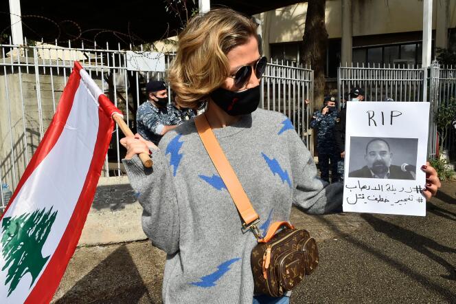Une manifestante tient une photo de Lokman Slim, lors d’un rassemblement devant le Palais de justice de Beyrouth, le 4 février 2021, à l’annonce de sa mort.