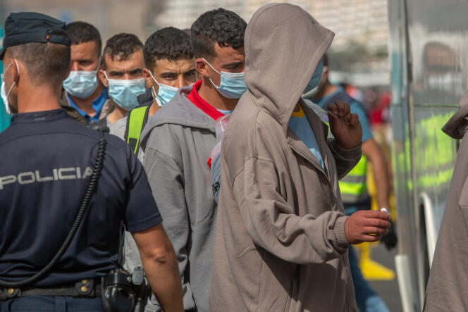 Des migrants embarquent dans un bus après avoir été secourus par les gardes-côtes espagnols sur l’île de Grande Canarie, le 23 novembre 2020.