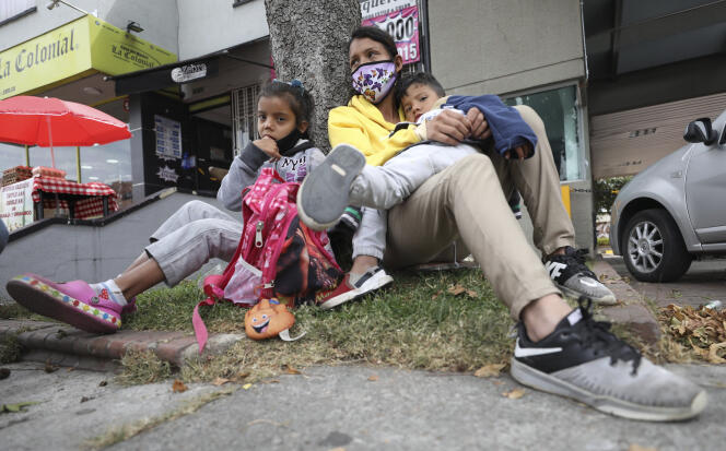 Une migrante vénézuélienne et ses enfants devant un centre commercial, à Bogota, en Colombie, le mardi 9 février 2021.