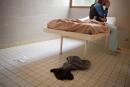 A patient placed in an isolated room sits on his bed at the psychiatric hospital "EPS de Ville Evrard, Centre psychiatrists du Bois de Bondy", on May 7, 2020, in Bondy, during a lockdown aimed at curbing the spread of the COVID-19 pandemic, the novel coronavirus. - The patients of the Centre psychiatrique du Bois de Bondy have been under strict lockdown since the beginning of the COVID-19 outbreak in France mid-March and they haven't received any visits from their relatives since. According to a tribune published by a group French psychiatrists early April 2020, a person affected by a psychiatric disease can suffer 1.5 or 2 times more often, compared to the rest of the population, from associated conditions, such as cardiovascular disorders, diabetes or hypertension, and are therefore more vulnerable to Covid-19. (Photo by Loic VENANCE / AFP)
