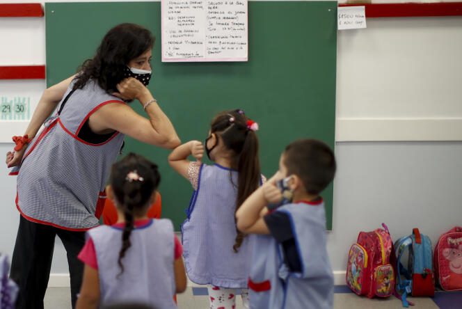 Une institutrice salue les élèves avec son coude lors de la reprise de l’école, le 17 février à Buenos Aires, Argentine.