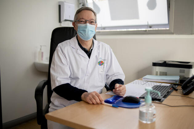 Le médecin du travail Benoît Mauguy porte sur sa blouse le badge multicolore « Je suis vacciné ».  Centre hospitalier intercommunal Poissy-Saint-Germain-en-Laye, le 17 février 2021.