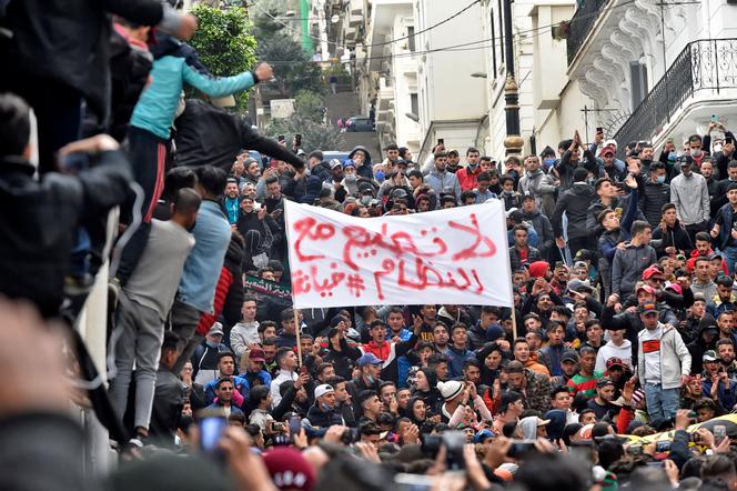 Protesters hold up a sign saying 