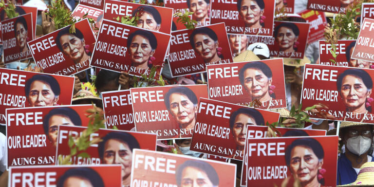 Protesters hold up placard with images of ousted leader Aung San Suu Kyi during an anti-coup protest in Mandalay, Myanmar, Sunday, Feb. 21, 2021. Police in Myanmar shot dead a few anti-coup protesters and injured several others on Saturday, as security forces increased pressure on popular revolt against the military takeover. (AP Photo)
