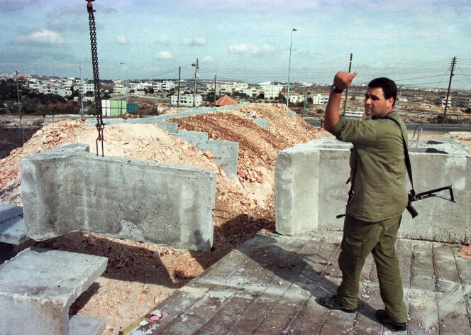Erection d’une barrière à l’entrée de la colonie israélienne de Psagot, en Cisjordanie, en 1998. A l’arrière plan, Ramallah.