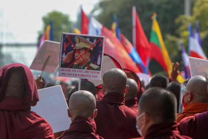 Des moines bouddhistes montrent une image défigurée du commandant en chef de l’armée birmane, le général Min Aung Hlaing, lors d’une marche de rue contre le coup d’Etat militaire à Mandalay, en Birmanie, vendredi 12 février 2021.