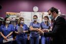 French Health Minister Olivier Veran (R) speaks with medical staff during a visit of the Villefranche-sur-Saone's Nord-Ouest hospital, a few days after it was targeted by cyberattacks, on February 22, 2021. / AFP / JEFF PACHOUD
